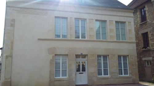 une grande maison blanche avec une porte blanche dans l'établissement Le Logis d'Isabelle, à Argentan