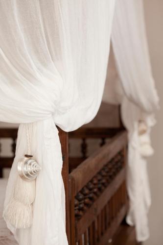 a close up of a bed with white curtains at Quartara Boutique Hotel in Panarea