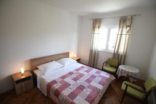 1 Schlafzimmer mit einem Bett, 2 Stühlen und einem Fenster in der Unterkunft Apartment Vodice in Vodice