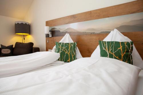 two beds in a hotel room with white sheets and pillows at Zum Fally - Landgasthof in Kirchberg am Wechsel