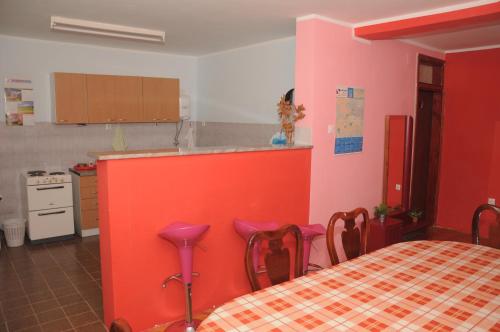 a kitchen with a table and a red wall at Smeštaj - sobe MARVEL in Niš