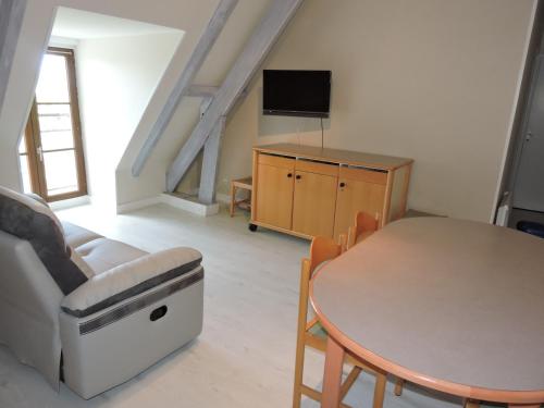 a living room with a table and a tv at Embarcadere ou Ecluse in Mareuil-sur-Cher
