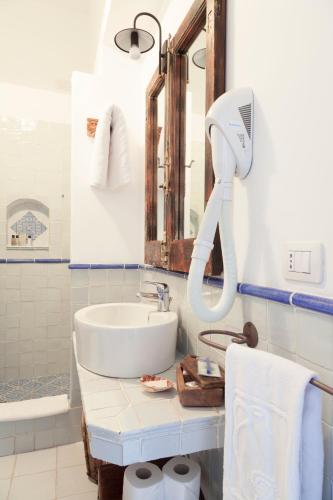 a bathroom with a sink and a mirror at Quartara Boutique Hotel in Panarea