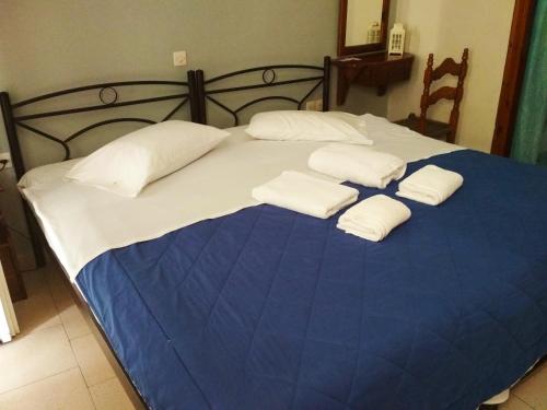 a bed with three white pillows on it at Konstantina Studios in Agios Nikitas