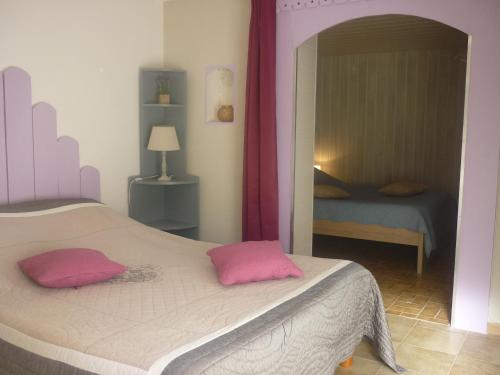 Massillargues-AttuechにあるEntre Vignes et Oliviersのベッドルーム1室(ピンクの枕が付いたベッド1台付)
