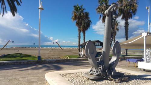 a statue in front of a beach with palm trees at Elcano in Málaga