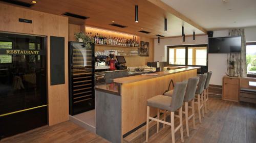 a restaurant with a bar with chairs in a room at Hotel Alpenfrieden in Rio Bianco