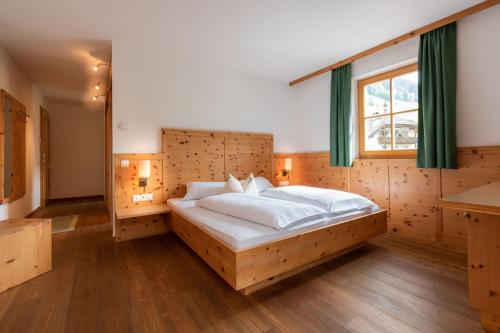 Un dormitorio con una cama grande y una ventana en Hotel Alpenfrieden, en Rio Bianco