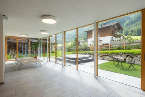 a large room with glass walls and a patio at Hotel Alpenfrieden in Rio Bianco