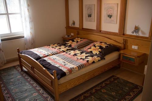ein Bett mit einer Decke in einem Schlafzimmer in der Unterkunft Ferienwohnung Heidrun Bemetz in Unterreitnau
