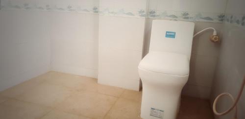 a bathroom with a white toilet in a corner at Hotel Ravi Mayur International in Chitradurga