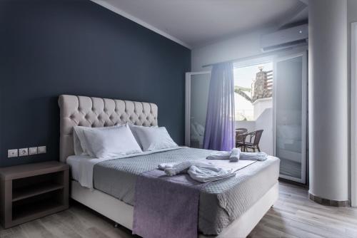 a bedroom with a large bed with a purple wall at Zante Calinica Hotel in Tsilivi