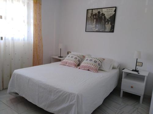 ミハス・コスタにあるApartamento El Faro de Mijasの白いベッド(枕付)が備わるベッドルームです。