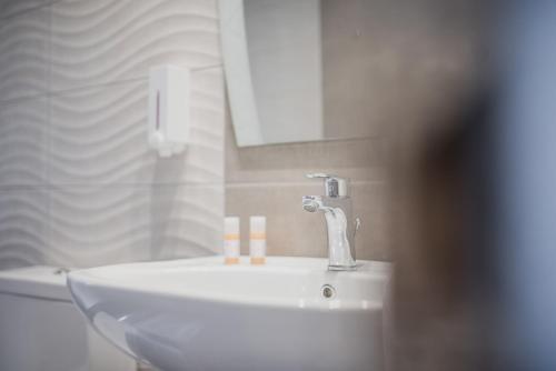 a bathroom with a sink with three candles on it at Zante Calinica Hotel in Tsilivi