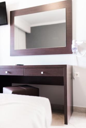 a bathroom with a wooden vanity with a mirror at Zante Calinica Hotel in Tsilivi