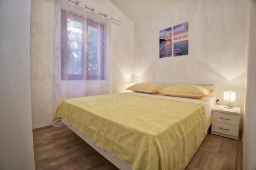 ein weißes Schlafzimmer mit einem Bett und einem Fenster in der Unterkunft Villa Nada in Neum