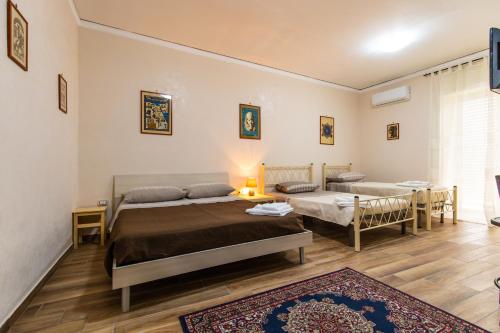 una camera con due letti, un divano e un tavolo di Casa di Annarella a Napoli