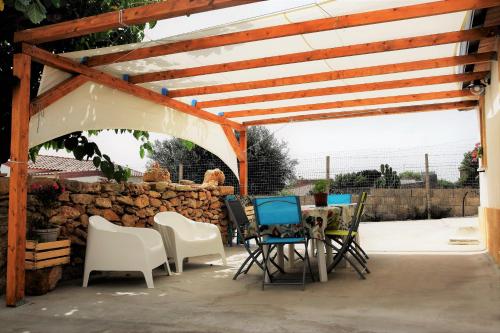 a patio with chairs and a table and a stone wall at Casa le Gebbie in Marzamemi