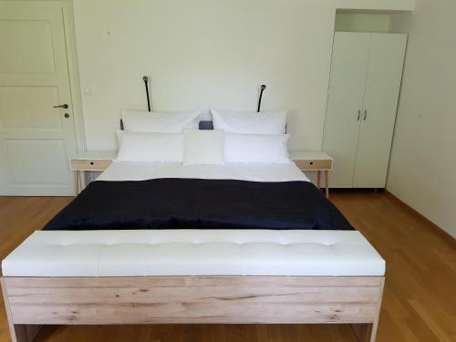 ein großes weißes Bett in einem Zimmer mit weißen Schränken in der Unterkunft SIPPO Apartments in Ljubljana