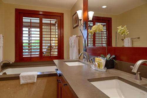 a bathroom with two sinks and a large mirror at Popular Ground Floor with Extra Grassy Area - Beach Tower at Ko Olina Beach Villas Resort in Kapolei