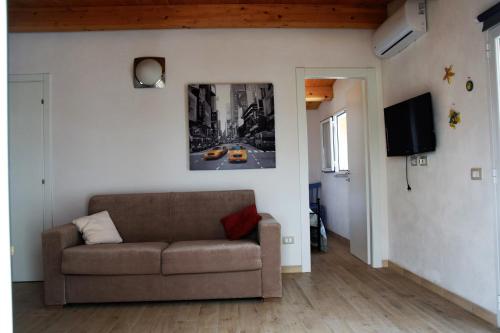 a living room with a couch and a picture on the wall at Casa le Gebbie in Marzamemi