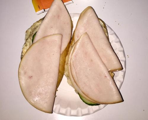a sandwich cut in half on a paper plate at Tenon Eräkievari mökit in Karigasniemi