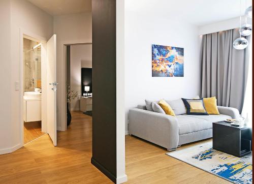 ein Wohnzimmer mit einem grauen Sofa und ein Wohnzimmer mit in der Unterkunft IRS ROYAL APARTMENTS Apartamenty IRS Neptun Park in Danzig