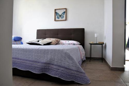 a bedroom with a large bed with a purple blanket at Casa le Gebbie in Marzamemi