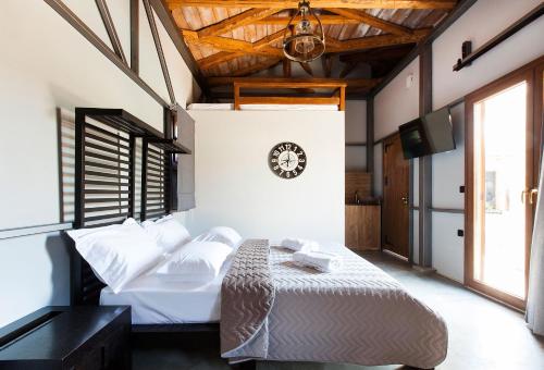 a bedroom with a bed and a clock on the wall at Casa Afytos - Adults Only in Afitos