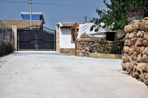 a driveway leading to a house with a gate at Casa le Gebbie in Marzamemi