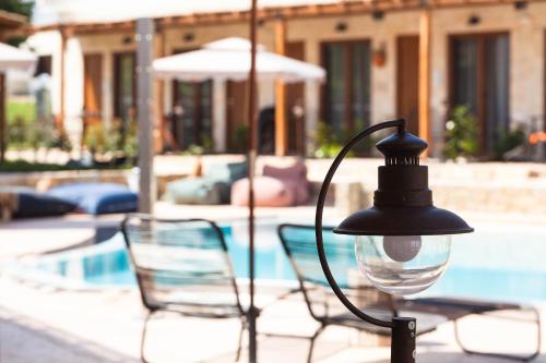 a street light with two chairs and a pool at Casa Afytos - Adults Only in Afitos