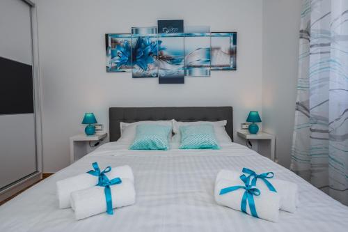 1 dormitorio con 1 cama blanca con arcos azules en Lavender & Mint, en Kaštela