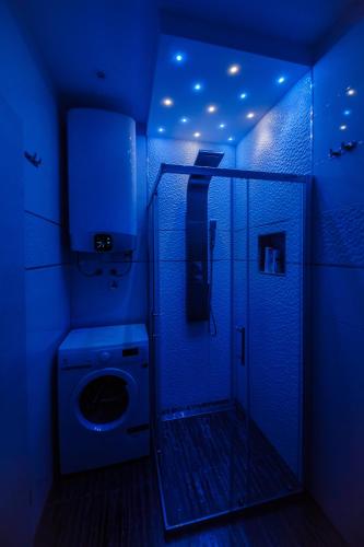 a blue bathroom with a toilet and a shower at Lavender & Mint in Kaštela