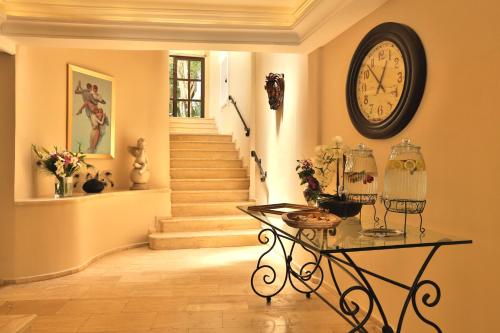 a hallway with a clock on the wall and a table at Torbahan Hotel in Torba