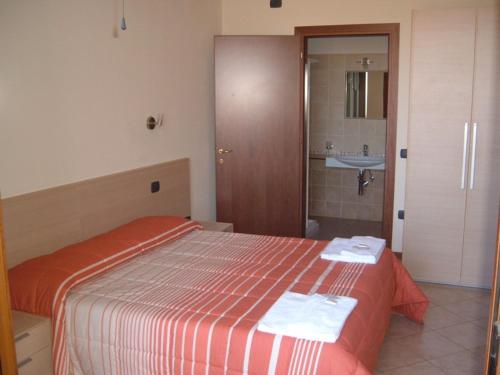 Hotel Magnolia في كوماكيو: غرفة نوم عليها سرير وفوط