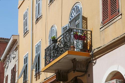 a balcony of a building with two plants on it at Studio Burić in Pula