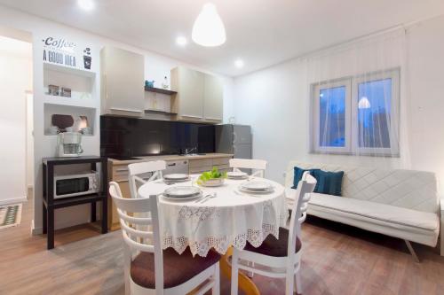 uma cozinha e sala de estar com mesa e cadeiras em Apartmani Olivette em Sibenik