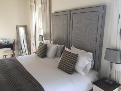 a bedroom with a large white bed with pillows at Horse & Hound in Delgany