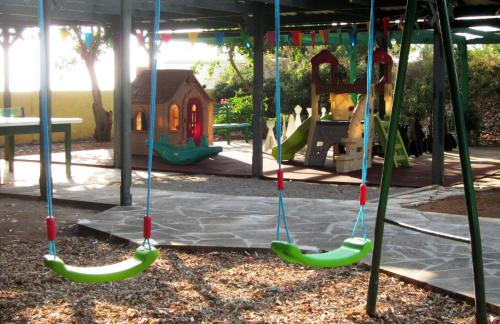 a playground with swings and a play structure at Marina Hotel in Ayia Napa
