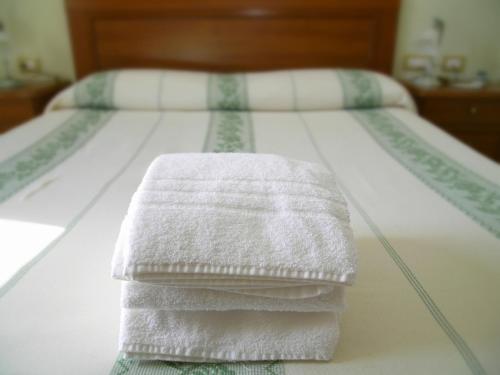 a stack of towels sitting on a bed at Hotel da Paolino in Trinità dʼAgultu