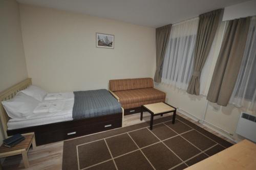a small bedroom with a bed and a chair at Apartments&Camping ZIP in Kremna