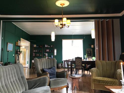 a living room with green walls and chairs and a table at Hótel Bjarkalundur in Reykhólar