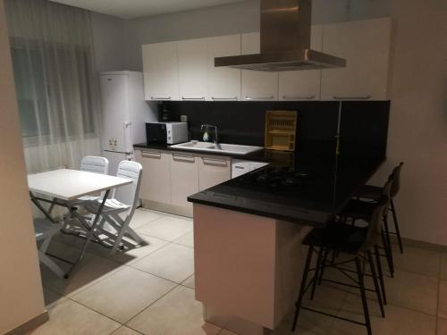 a kitchen with white cabinets and a black counter top at Le lagon de Hammamet in Hammamet