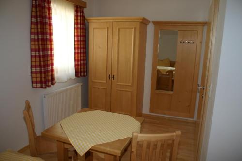 a dining room with a table and a cabinet at Stallerhof in Hüttschlag