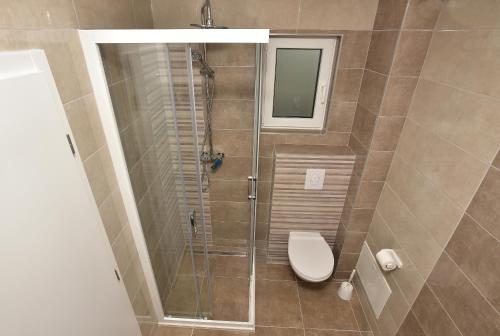 a bathroom with a toilet and a glass shower at Holiday Home Ivan in Makarska
