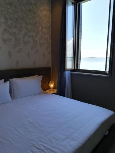 a bedroom with a large bed with a window at Isola di San Servolo - Centro Soggiorno in Venice