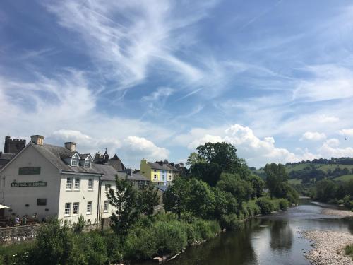 a view of a river in a town with buildings at Riverside in Brecon
