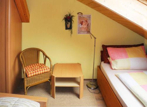 a bedroom with a bed and a chair and a table at Ferienwohnung Wiese in Riedenburg