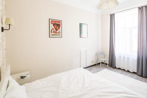 利維夫的住宿－#1 APARTMENT，白色的卧室设有床和窗户