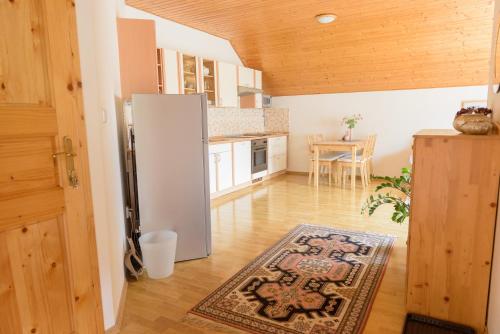 a kitchen with a refrigerator and a table with a rug at Žltý Dom in Terchová